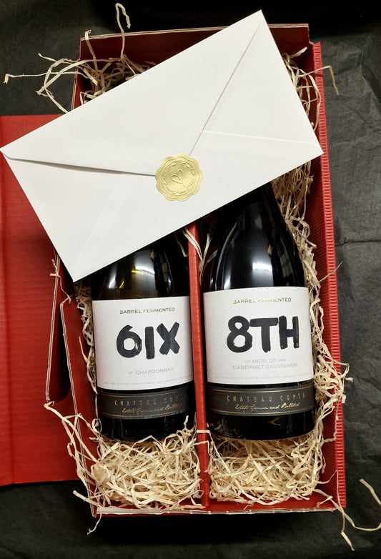 Two bottles of wine labeled '6IX' and '8TH' in a decorative box with straw and an envelope.